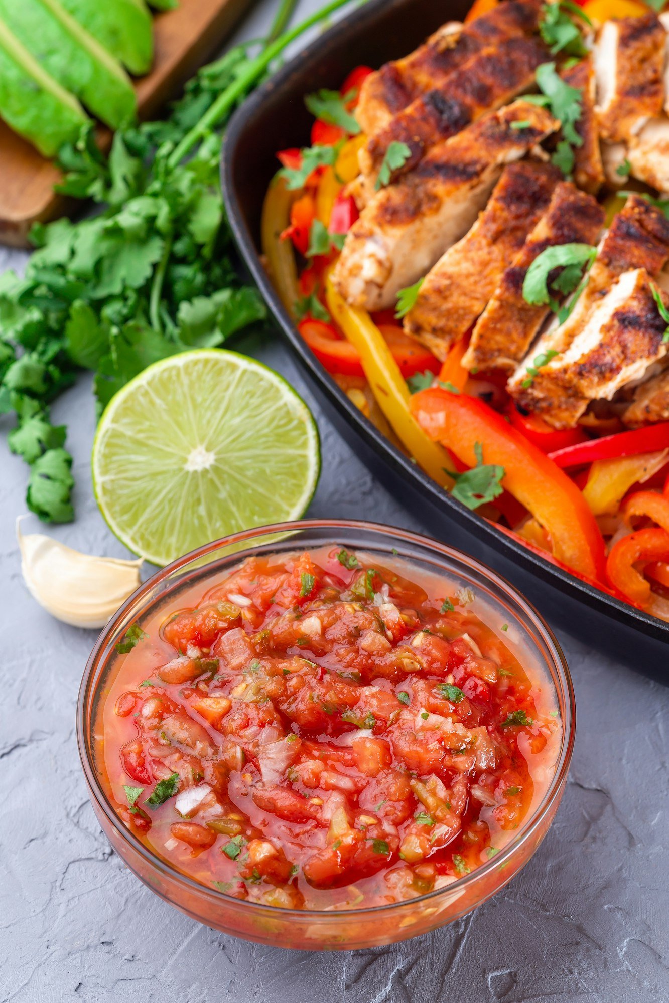 Tex-Mex cuisine salsa Asada sauce with Chicken Fajitas, vertical