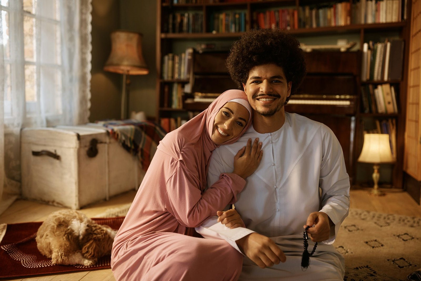 Young happy Muslim couple at home looking at camera.