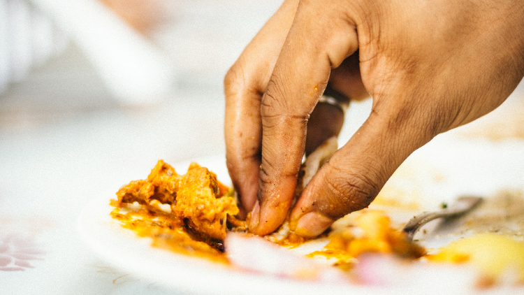 Een groep mensen geniet van een traditionele maaltijd door met hun handen te eten, wat een gevoel van verbondenheid en authenticiteit creëert.