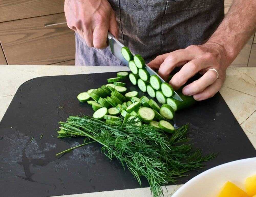 Men's hands holding knife and slicing vegetables